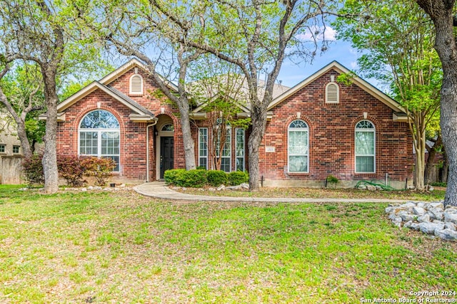 view of front of home with a front yard and brick siding