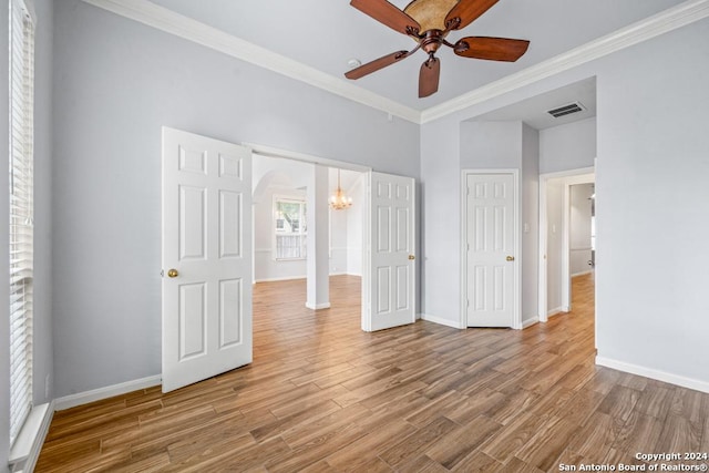 unfurnished bedroom with ornamental molding, wood finished floors, visible vents, and baseboards