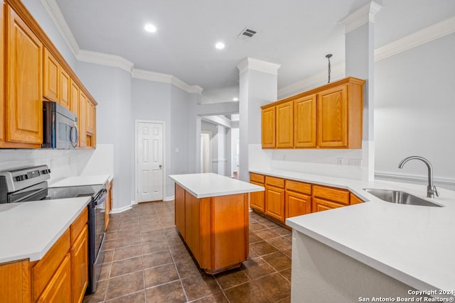 kitchen featuring visible vents, a kitchen island, appliances with stainless steel finishes, light countertops, and a sink