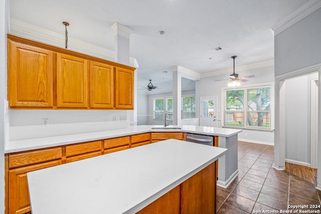 kitchen featuring dishwasher, light countertops, a kitchen island, and a sink