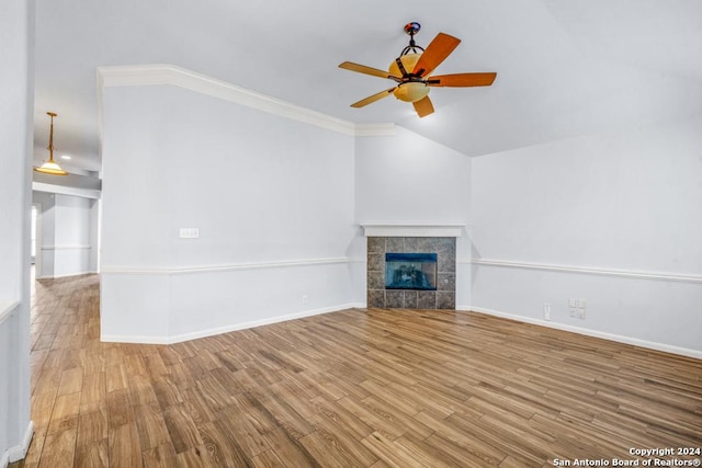 unfurnished living room with ceiling fan, light wood finished floors, a tile fireplace, and baseboards