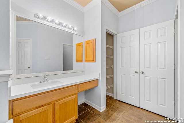 bathroom featuring ornamental molding, a closet, vanity, and baseboards