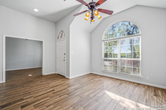 spare room featuring vaulted ceiling, wood finished floors, a ceiling fan, and baseboards