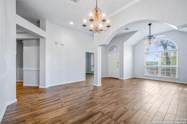 interior space with visible vents, baseboards, arched walkways, wood finished floors, and ceiling fan with notable chandelier