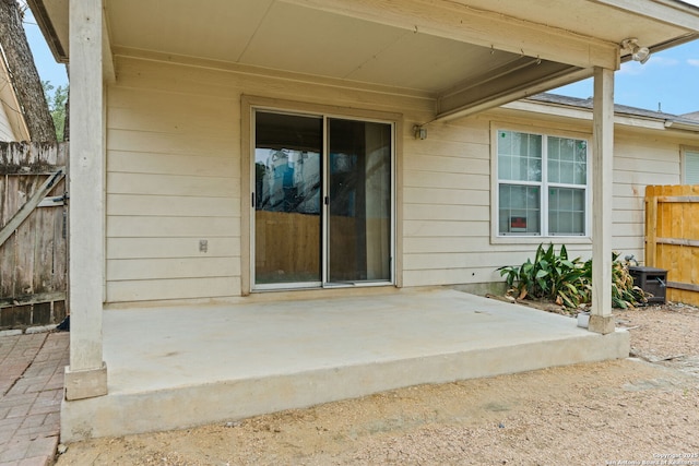 entrance to property featuring a patio and fence