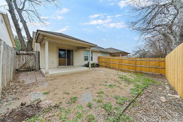 back of house with a patio area, a fenced backyard, and a gate