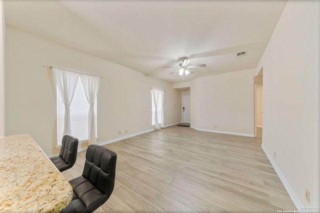 office space featuring light wood-style floors, visible vents, baseboards, and a ceiling fan