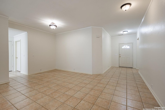 spare room featuring light tile patterned floors, baseboards, and ornamental molding