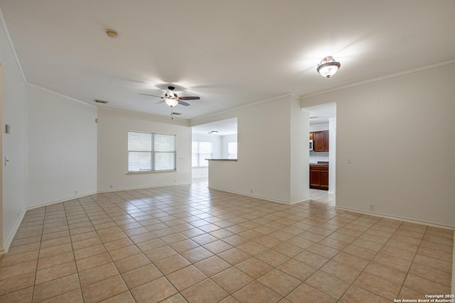 unfurnished room featuring crown molding, light tile patterned floors, a ceiling fan, and baseboards