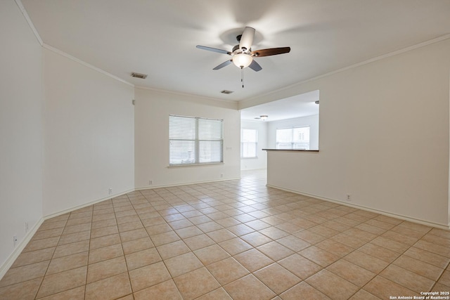 spare room featuring light tile patterned flooring, visible vents, a ceiling fan, and ornamental molding