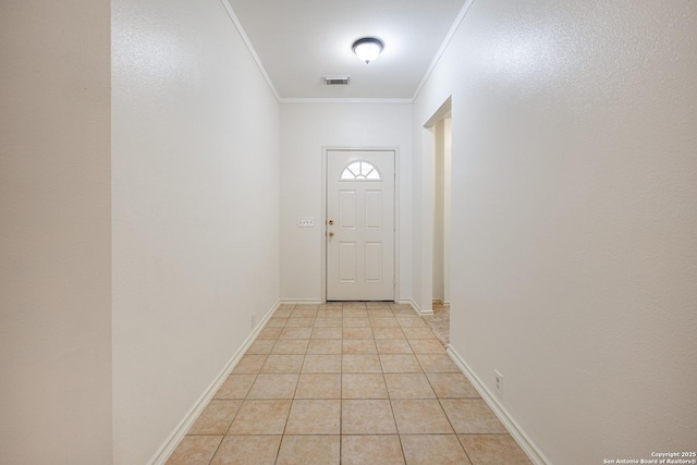 doorway to outside featuring light tile patterned floors, visible vents, baseboards, and crown molding