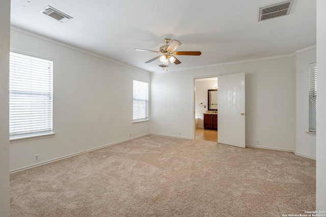 spare room featuring crown molding, light colored carpet, and visible vents