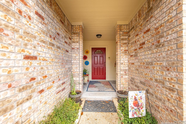 view of exterior entry with brick siding