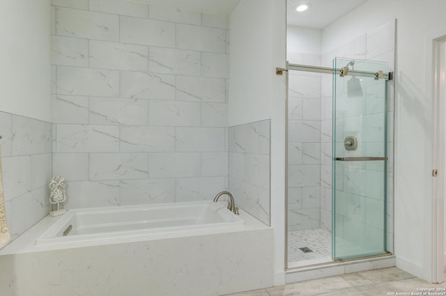 full bathroom with a shower stall and a bath