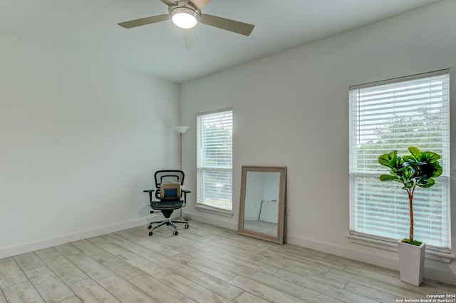 unfurnished office with light wood finished floors, baseboards, and a ceiling fan