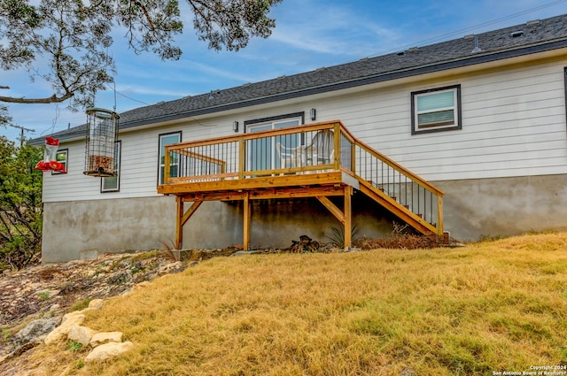 rear view of house featuring stairs, a lawn, and a wooden deck