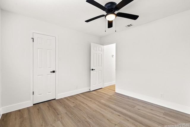 empty room featuring baseboards, visible vents, ceiling fan, and light wood finished floors