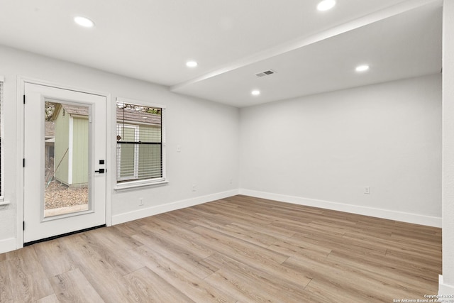 unfurnished room with baseboards, light wood finished floors, visible vents, and recessed lighting