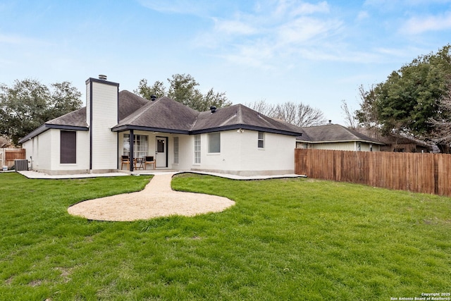 rear view of house featuring central AC, fence, a yard, a chimney, and a patio area