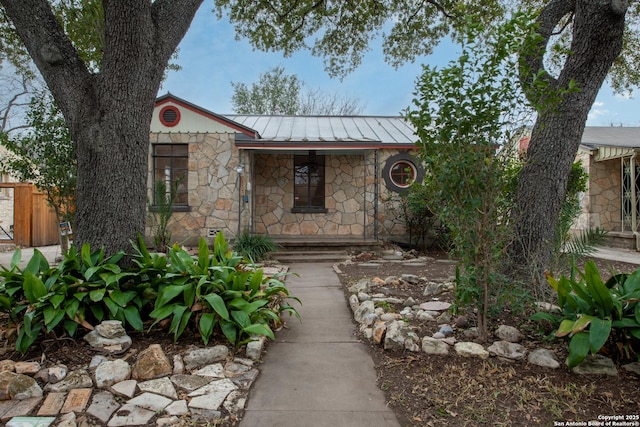 view of front of property featuring stone siding, a standing seam roof, and metal roof