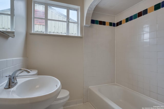 full bathroom with toilet, tile patterned flooring, baseboards, and a sink