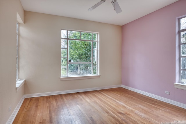 spare room with light wood-style floors, baseboards, and a ceiling fan