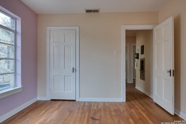 unfurnished bedroom featuring baseboards, visible vents, and light wood-style flooring