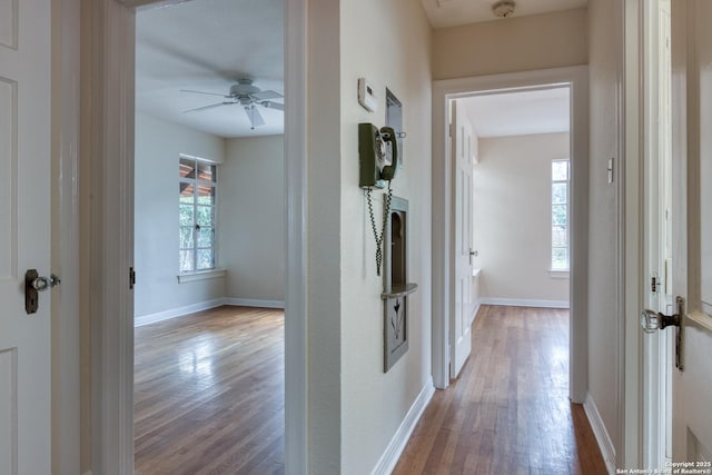 hallway featuring wood finished floors and baseboards