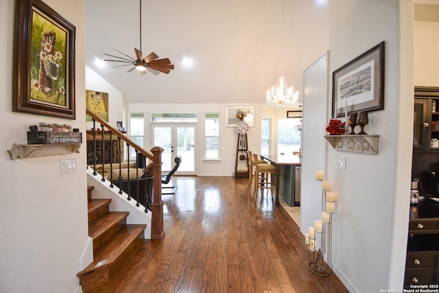 foyer featuring baseboards, stairway, wood finished floors, french doors, and ceiling fan with notable chandelier