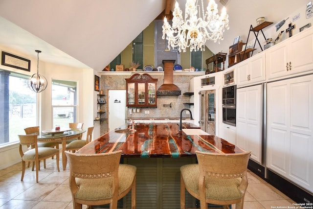 dining room featuring light tile patterned floors, high vaulted ceiling, and a notable chandelier