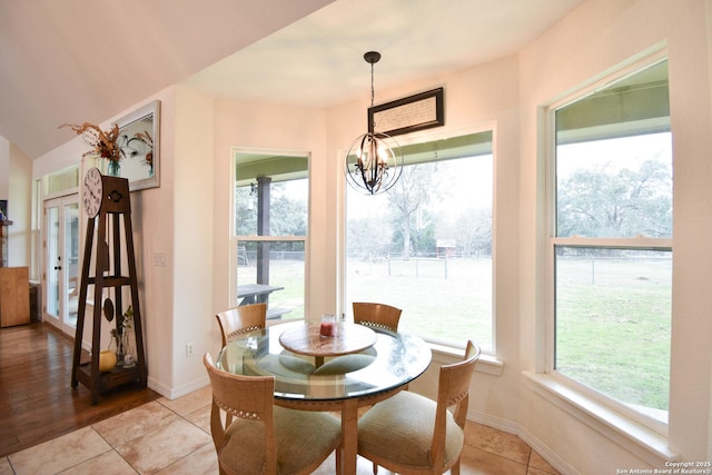 dining space featuring a chandelier, baseboards, and a healthy amount of sunlight