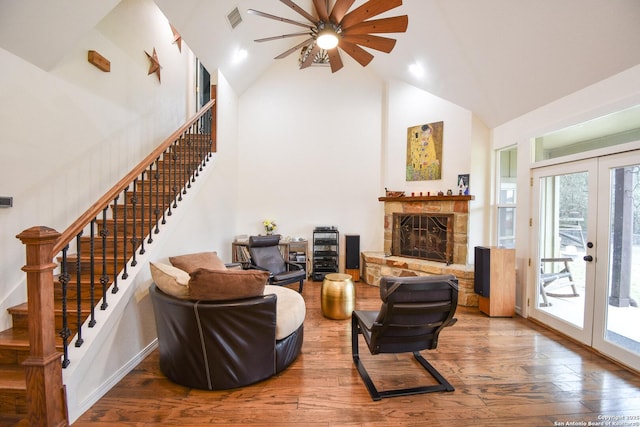 living room featuring french doors, visible vents, stairway, wood finished floors, and high vaulted ceiling