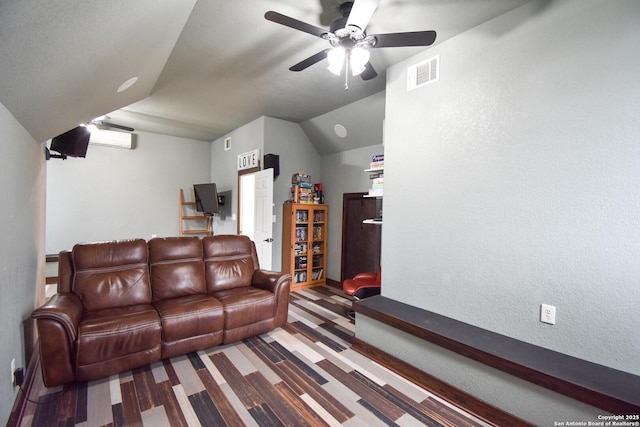 living area with lofted ceiling, visible vents, a textured wall, a wall mounted AC, and a ceiling fan