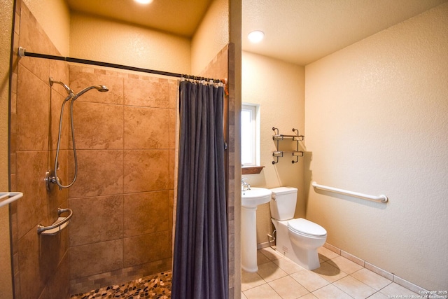 full bath featuring baseboards, a shower stall, toilet, and tile patterned floors