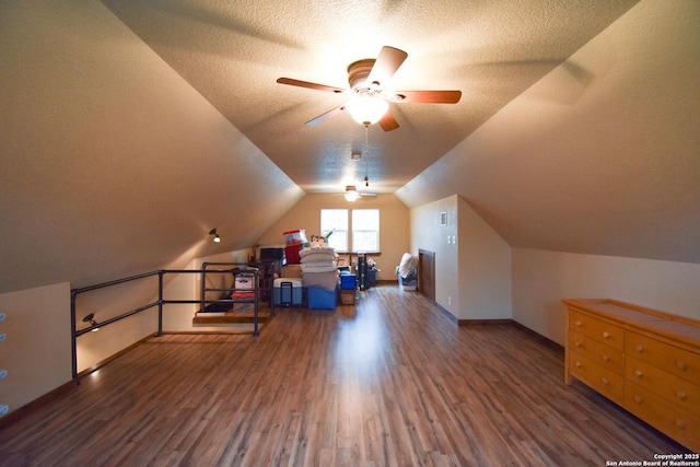 additional living space with dark wood-style floors, lofted ceiling, ceiling fan, a textured ceiling, and baseboards