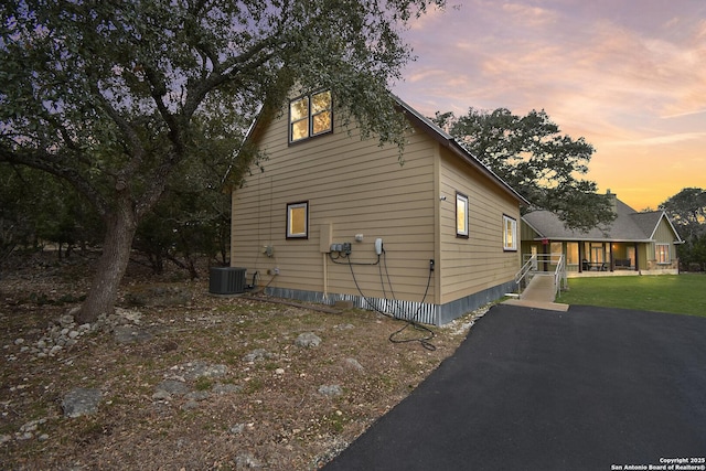 view of property exterior with driveway and cooling unit