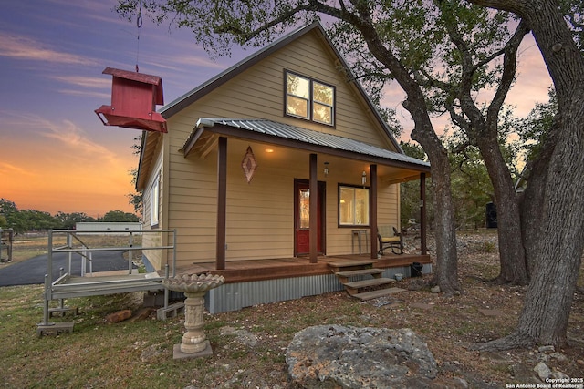 chalet / cabin featuring covered porch and metal roof