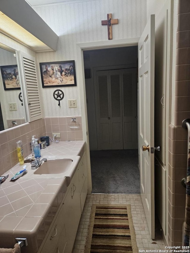 bathroom with tile patterned floors, vanity, and wallpapered walls