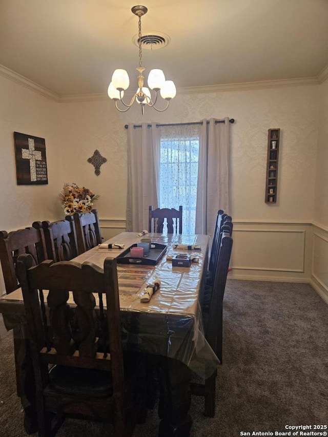 carpeted dining area featuring crown molding, a decorative wall, visible vents, and a notable chandelier