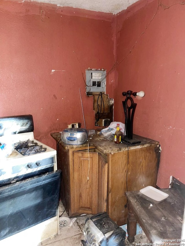 interior space featuring gas range gas stove, brown cabinetry, and electric panel