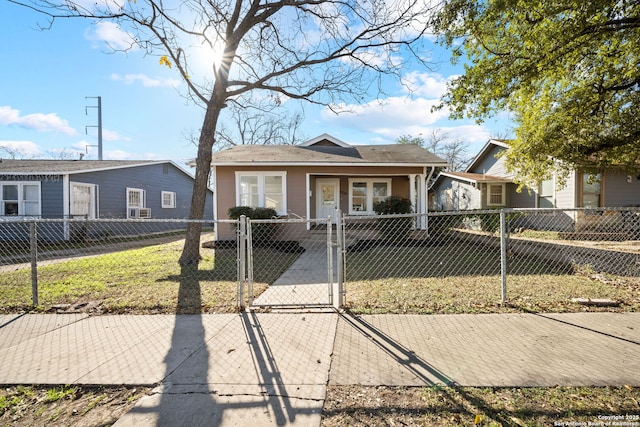 bungalow with a fenced front yard, a front yard, and a gate