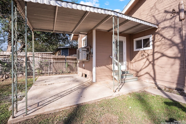 view of patio / terrace with entry steps, cooling unit, fence, and a carport