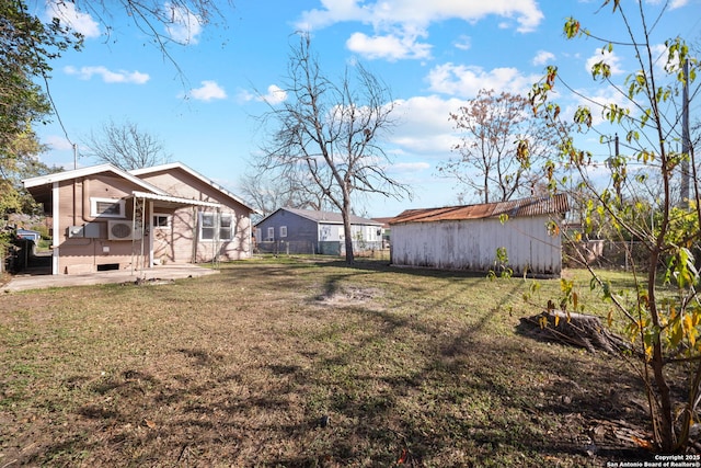 view of yard with a storage unit, a patio area, fence, and an outdoor structure