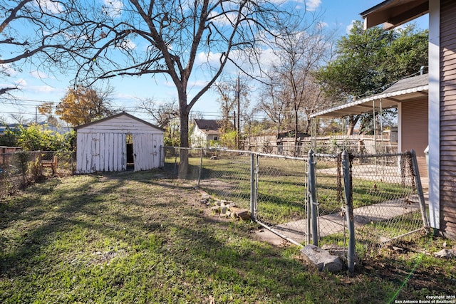 view of yard featuring a fenced backyard, a gate, a storage unit, and an outbuilding