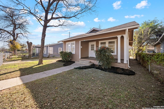 view of front of home featuring a front lawn, a porch, and fence