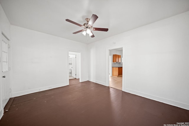 empty room with ceiling fan and baseboards