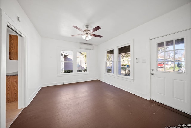 interior space with ceiling fan, dark wood-type flooring, a wall mounted air conditioner, and baseboards