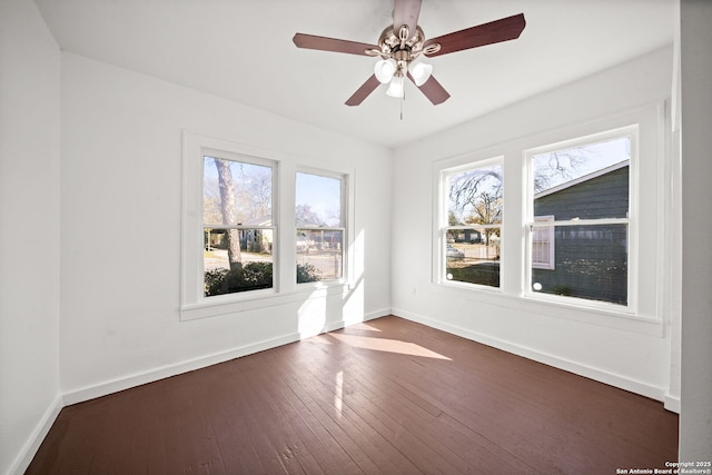 unfurnished room featuring ceiling fan, dark wood finished floors, and baseboards