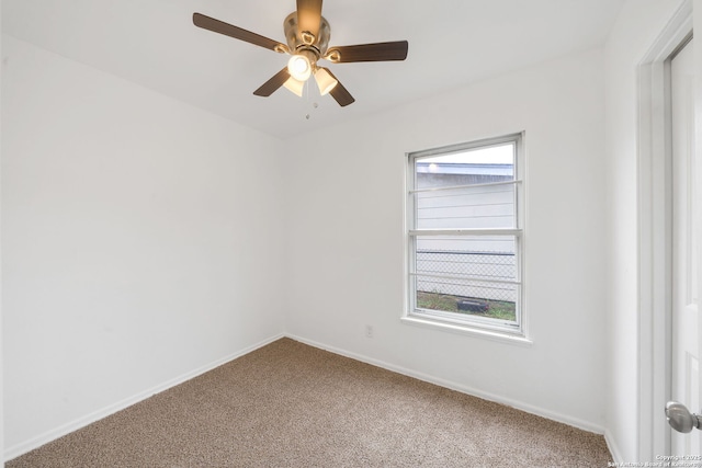 carpeted spare room with ceiling fan and baseboards