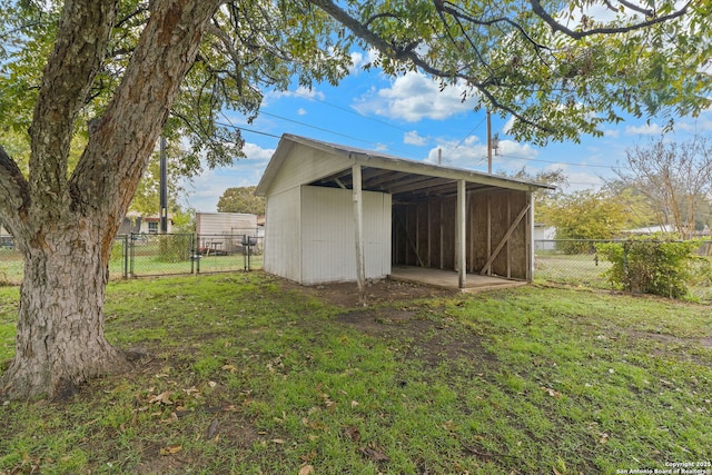 view of pole building with a carport, a gate, a lawn, and fence